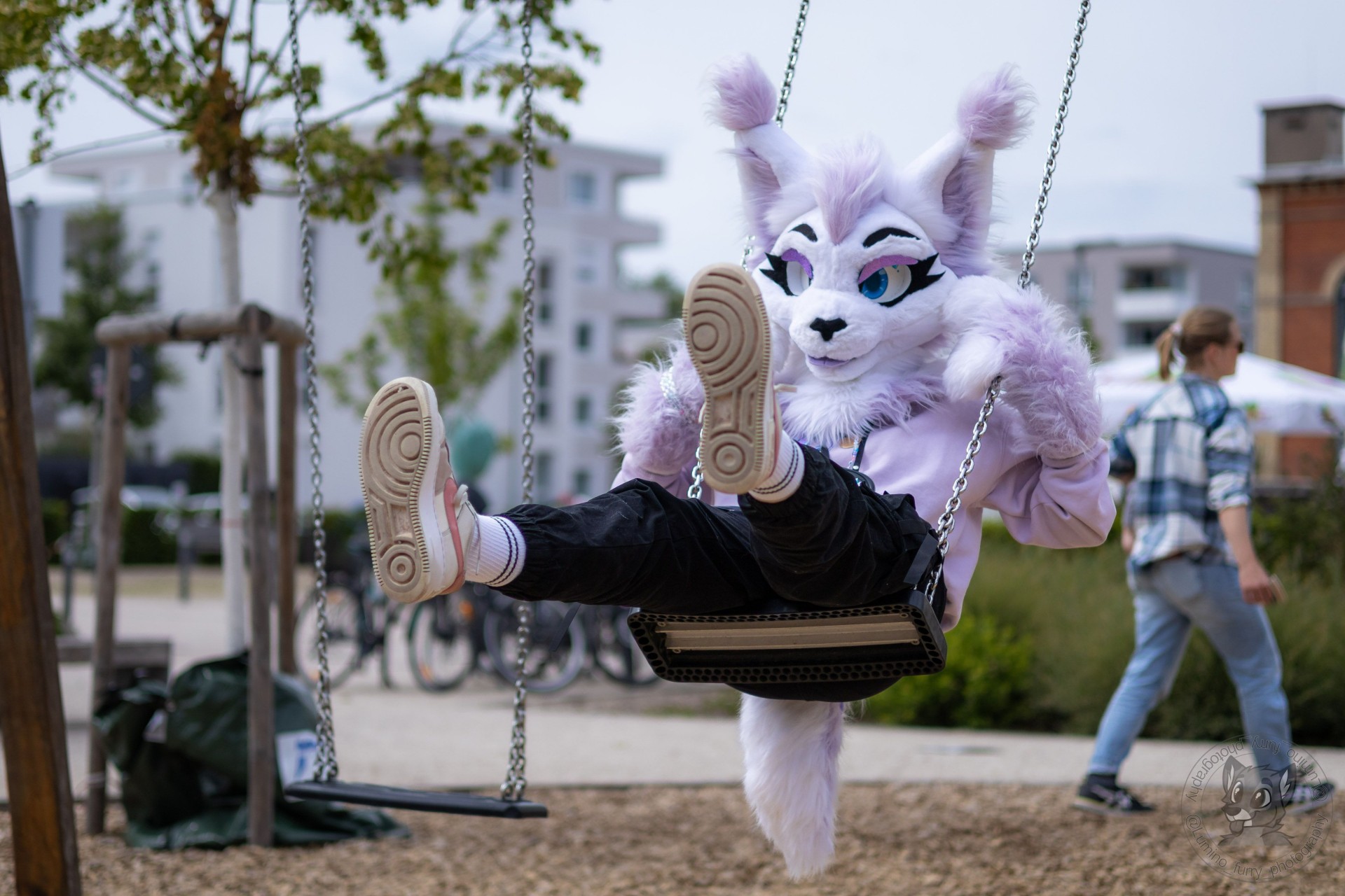 Furries eine Katzengestalt in Rosa auf einer Schaukel